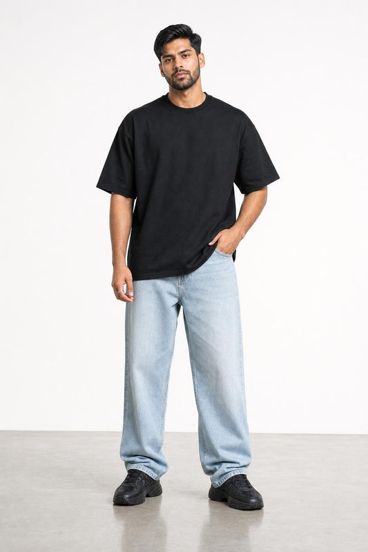 Plain oversized tee in black, front view on him