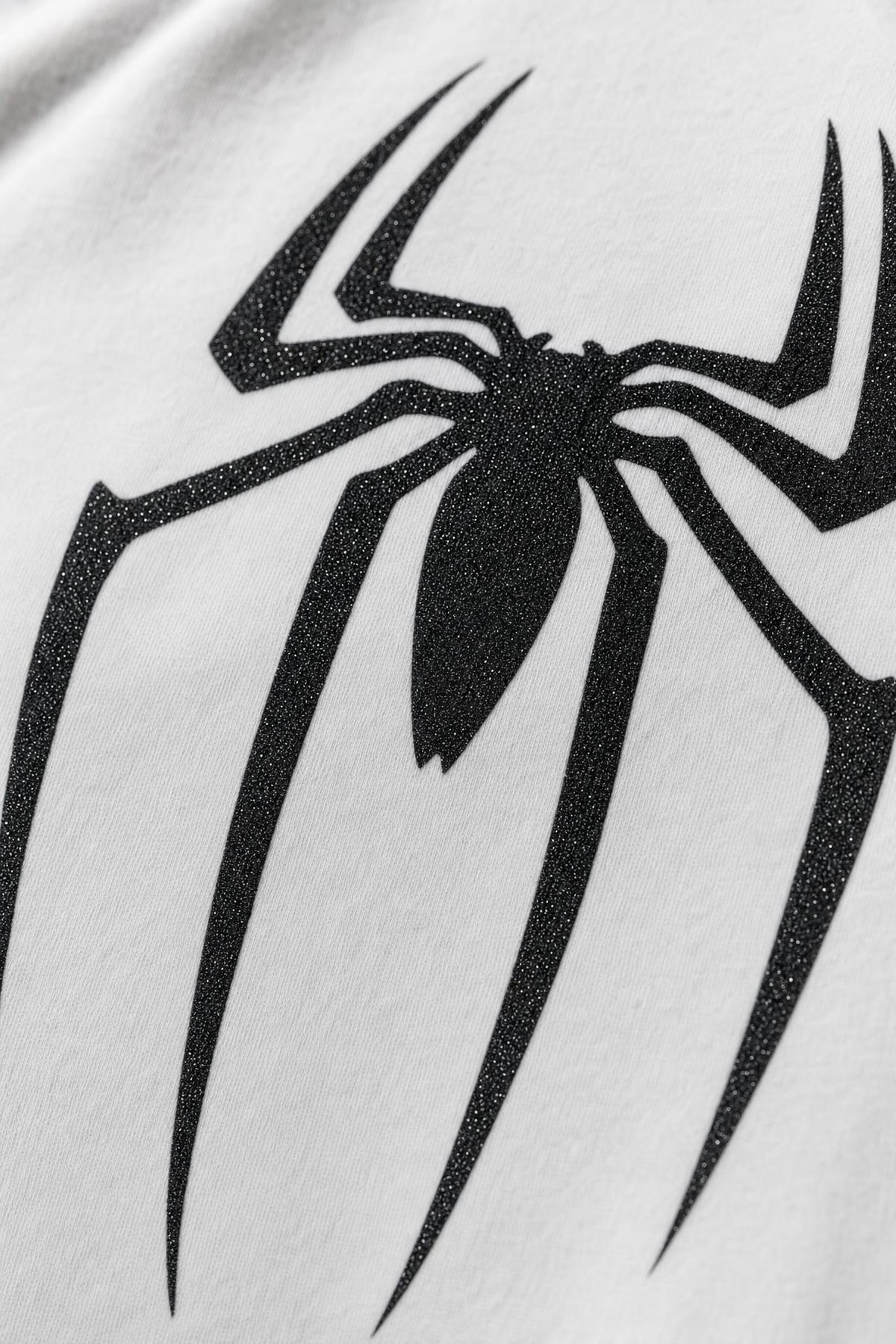 Spider glitter raglan tee with black sleeves, close view of the black glitter print